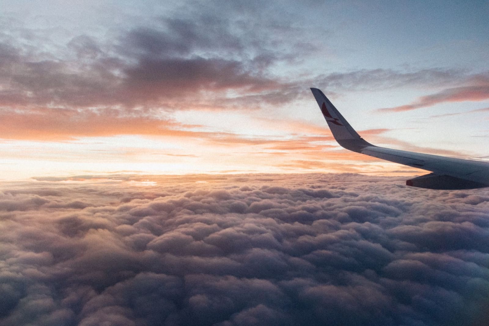 Captivating view from the airplane showcasing clouds and vibrant sunset hues, conveying the essence of air travel.